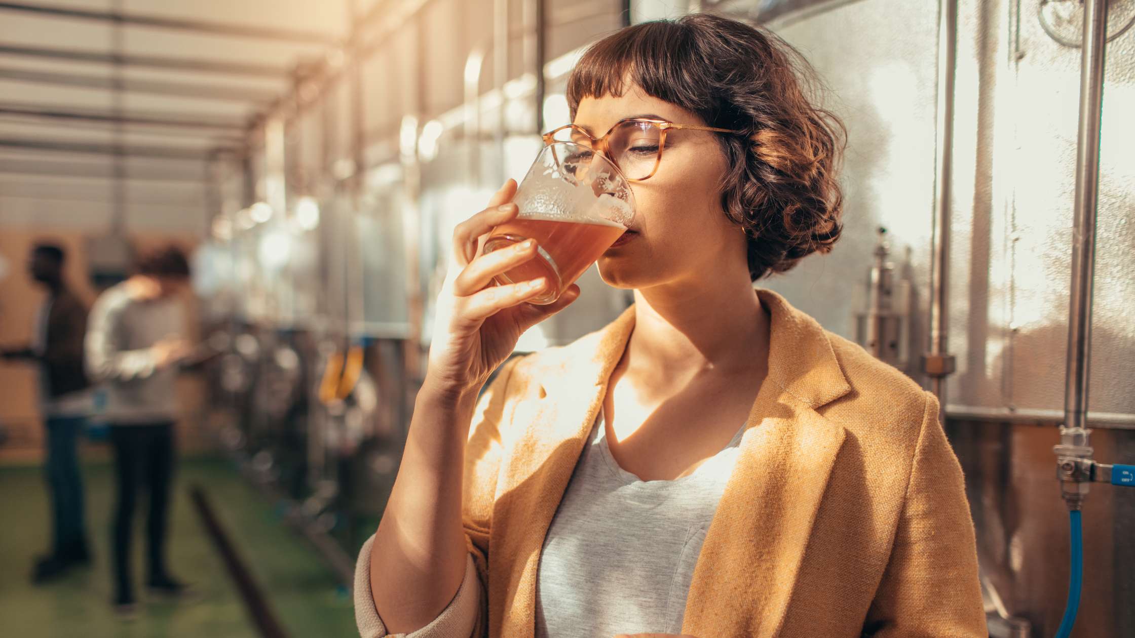 Woman tasting beer at brewery